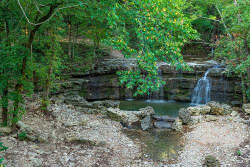 a waterfall in the middle of a forest at Westgate Branson Woods Resort in Branson