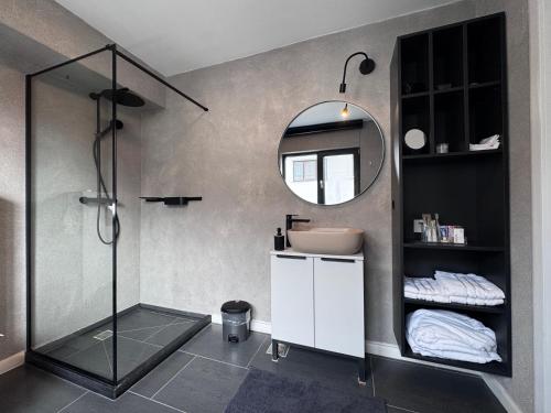 Un baño con ducha, lavabo y espejo. en AFI Apartments, en Suceava