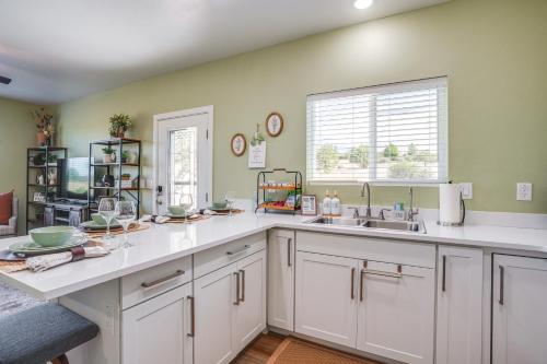 a kitchen with white cabinets and a sink and a window at Panoramic View! Prescott Casita Near Mtns and Hiking in Chino Valley