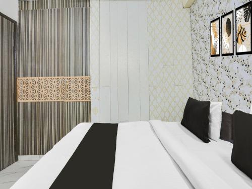 a bedroom with a large white bed in it at Super Hotel O Chhatarpur Formerly Royal Galaxy in New Delhi