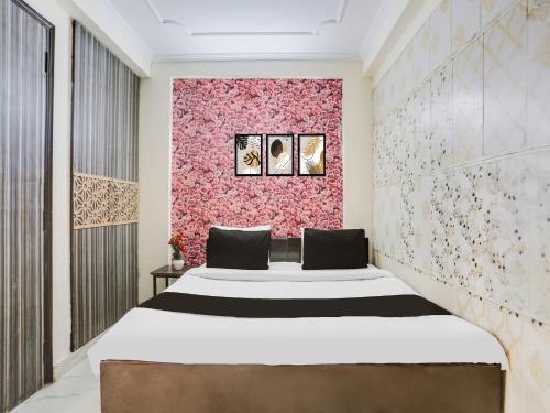 a bedroom with a bed and a pink wall at Super Hotel O Chhatarpur Formerly Royal Galaxy in New Delhi