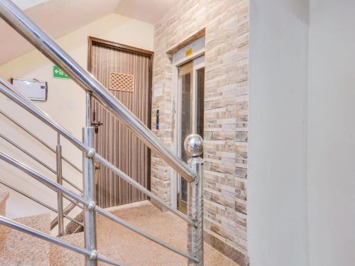 a staircase in a building with a stone wall at Super Hotel O Chhatarpur Formerly Royal Galaxy in New Delhi