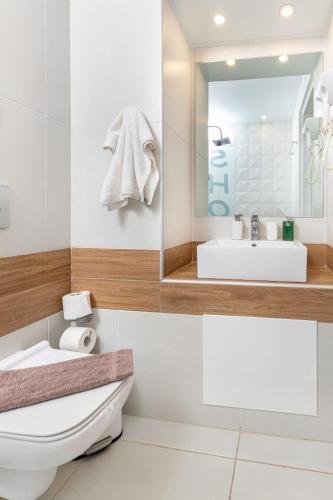 a bathroom with a white toilet and a sink at Notus Chania Crete in Chania Town