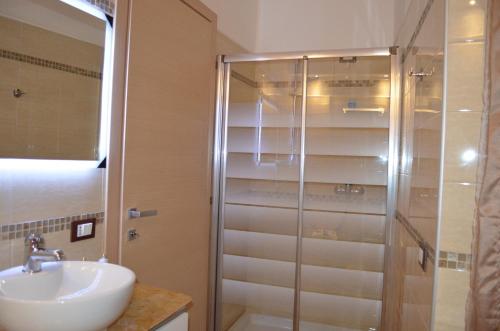 uma casa de banho com um lavatório e uma cabina de duche em vidro. em La Gemma em Roe