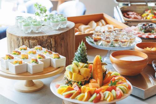 a buffet of food with cheese and fruit on plates at THE KNOT SAPPORO in Sapporo