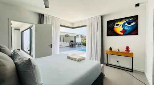 a bedroom with a bed and a painting on the wall at Un havre de paix in Calodyne