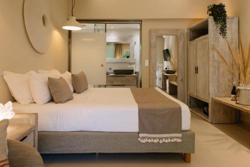 a bedroom with a large white bed in a room at Sea Nymphs Suites in Agia Anna Naxos