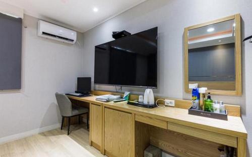 a room with a desk with a large television on the wall at Hotel Primo Daejeon in Daejeon