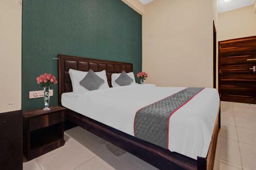 a bedroom with a large bed and a green wall at Collection O Aloft in Jaipur