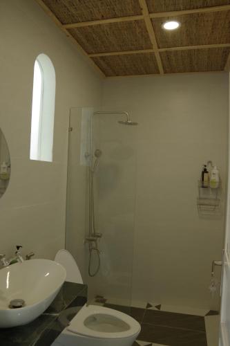 a bathroom with a shower and a toilet and a sink at Rosee de Kala - Golden Buurin in Di Linh