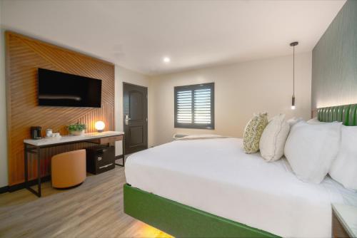 a bedroom with a large white bed and a desk at LYFE INN & SUITES by AGA- North Hollywood Near Universal Studios in North Hollywood