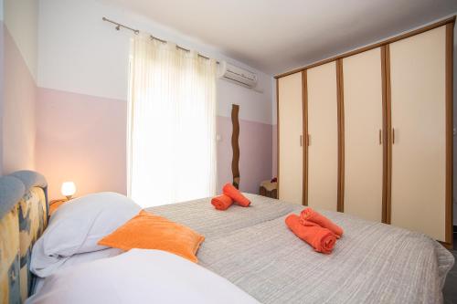 1 dormitorio con 2 toallas naranjas en una cama en Apartments Saldun, en Trogir