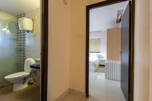 a bathroom with a toilet and a mirror at Luxury 2BHK Apartment Near Candolim Beach in Candolim