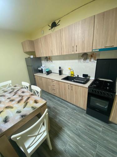 a kitchen with wooden cabinets and a table with chairs at Apartamentele Liliacul in Sighetu Marmaţiei