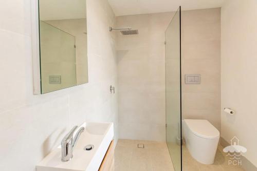 a bathroom with a sink and a mirror and a toilet at 28 Ennisvale Avenue in Sandy Point