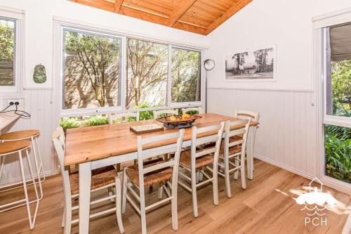 a dining room with a wooden table and chairs at Banksia Beauty in Sandy Point