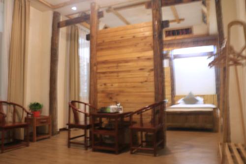 a room with a table and chairs and a window at Wulingyuan Zhangjiajie National Forest Park Qique Villa in Zhangjiajie