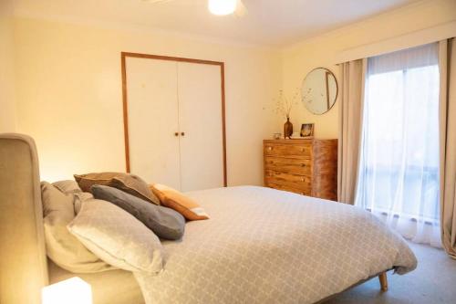 Un dormitorio con una cama y una cómoda y una ventana. en The Sandy Shack, en Sandy Point