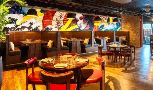 a restaurant with tables and chairs and a mural at Millennium Place Dubai Marina in Dubai