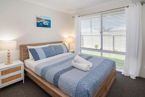 a bedroom with a large bed with a window at Dunsborough Sunrise in Dunsborough