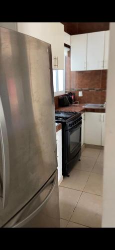 a kitchen with a stainless steel refrigerator and a stove at Lomas de Mazatlán in Mazatlán