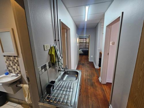 a small kitchen with a sink and a hallway at Stay at 126 in Bloemfontein