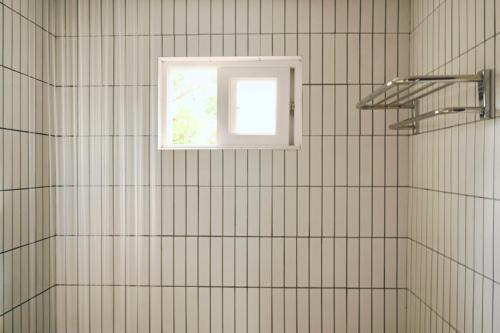 a bathroom with a window and a shower at Pyoseon Mansion in Seogwipo