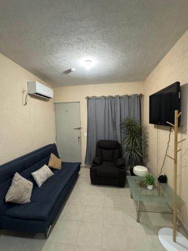 a living room with a blue couch and a chair at Departamento TanXime in El Jobo