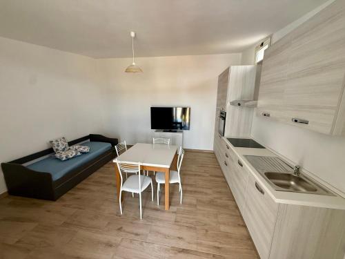 a small kitchen with a table and a couch in a room at Appartament Piras&Tascedda Barisardo 4 in Bari Sardo