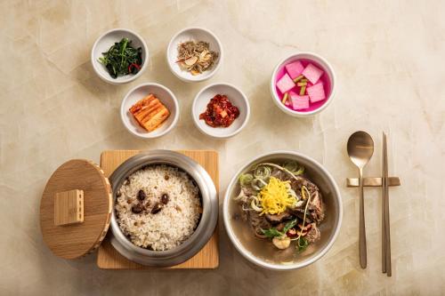 a table with bowls of food and bowls of different foods at The Siena PRIMO in Seogwipo