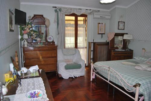 a bedroom with two beds and a chair and a dresser at Casa Pontecorvi in Velletri