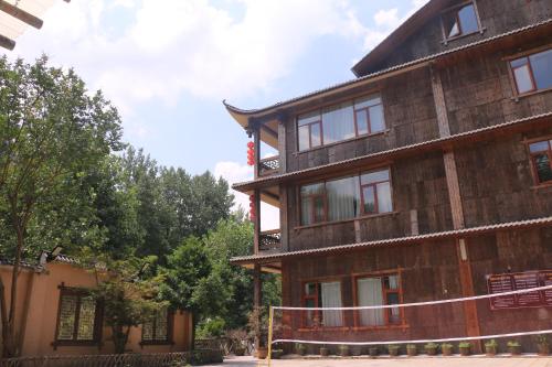 a large wooden building with a fence in front of it at Wulingyuan Zhangjiajie National Forest Park Qique Villa in Zhangjiajie