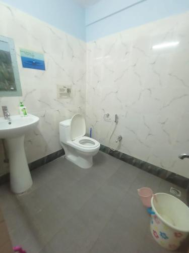 a bathroom with a toilet and a sink at Hotel Little Hut - 550 mts from Mall Road in Darjeeling