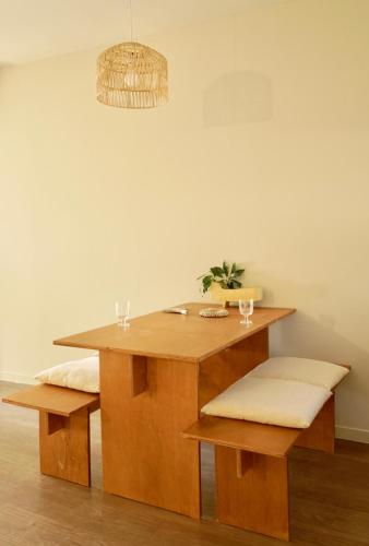 a wooden table with two benches and a light fixture at Pyoseon Mansion in Seogwipo