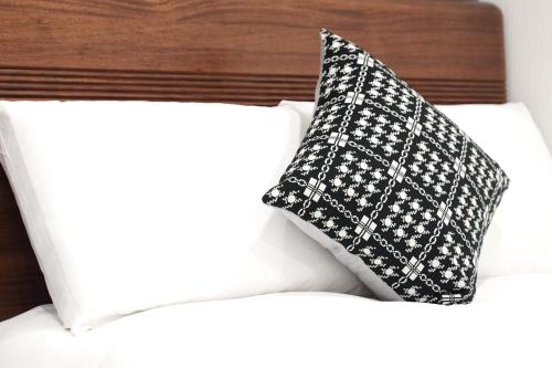 a black and white pillow sitting on top of a bed at Nihonbashi Royal in Osaka
