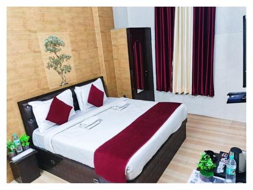 Un dormitorio con una cama grande con almohadas rojas. en Hotel Ravi B-R Group In Jaipur, en Jaipur