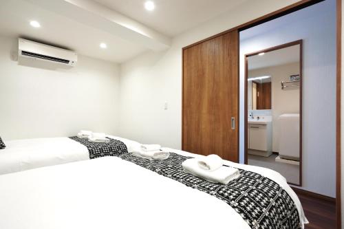 a bedroom with two beds and a mirror at Nihonbashi Royal in Osaka