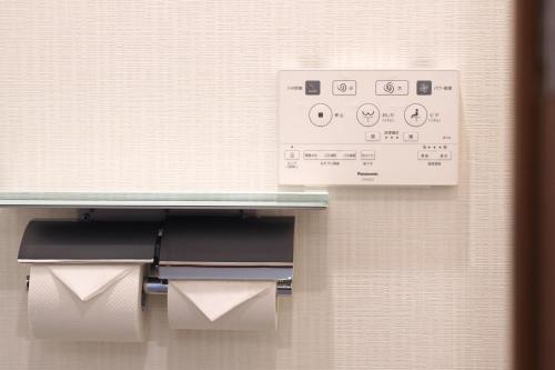 a toilet paper dispenser on a wall in a bathroom at Nihonbashi Royal in Osaka