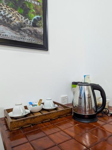 a tea kettle sitting on a table with a tea set at Nehansa Resort and safari in Tissamaharama