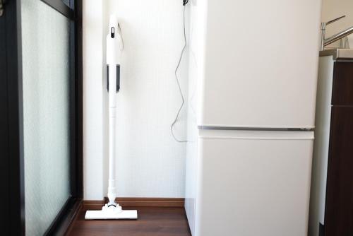 a white vacuum in a kitchen next to a refrigerator at Nihonbashi Royal in Osaka