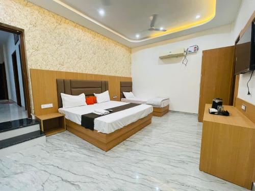 a bedroom with a bed and a flat screen tv at Hotel Pilgrim walking distance From Golden Temple in Amritsar