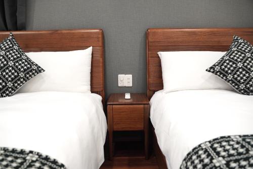 two beds with black and white pillows in a room at Nihonbashi Royal in Osaka