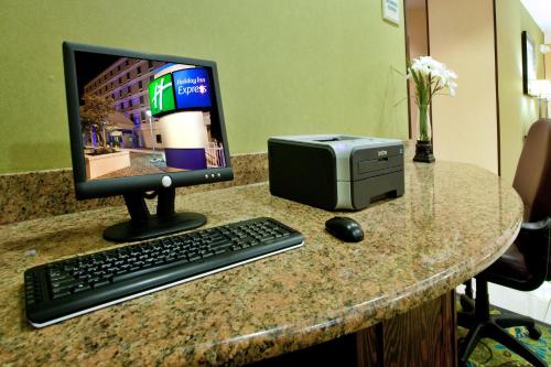 a desk with a computer monitor and a printer at Holiday Inn Express - Richmond Downtown by IHG in Richmond
