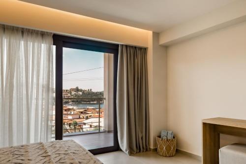 a bedroom with a bed and a large window at Ostria Village in Syvota