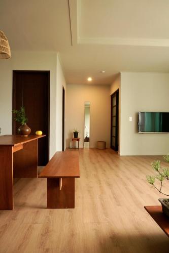 a living room with a table and a flat screen tv at Pyoseon Mansion in Seogwipo