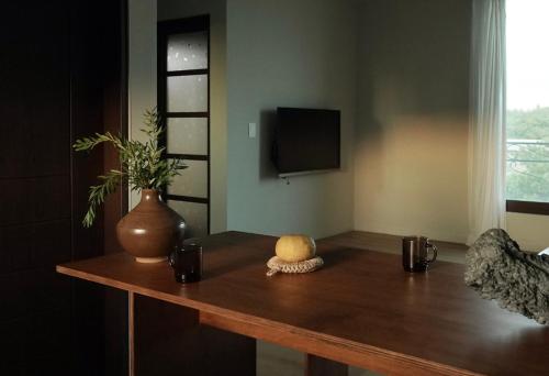 a wooden table with a vase on top of it at Pyoseon Mansion in Seogwipo