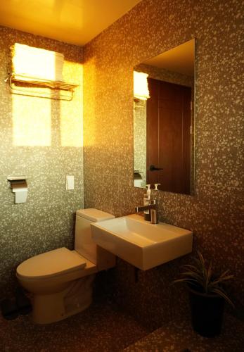 a bathroom with a toilet and a sink and a mirror at Pyoseon Mansion in Seogwipo