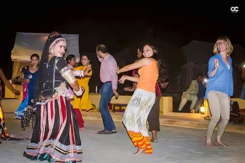 a group of women dancing on the stage at a performance at Jaisalmer Desert Resort in Jaisalmer