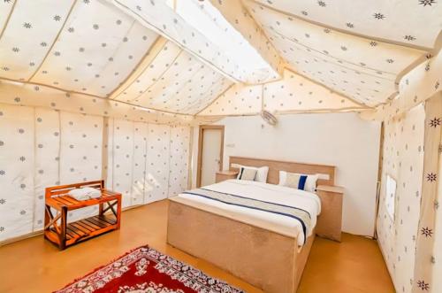a bedroom with a bed and a table in a room at Jaisalmer Desert Resort in Jaisalmer