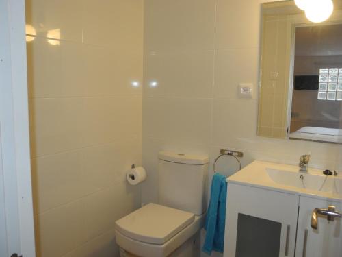 a white bathroom with a toilet and a sink at Apartamento Valencia in Catarroja